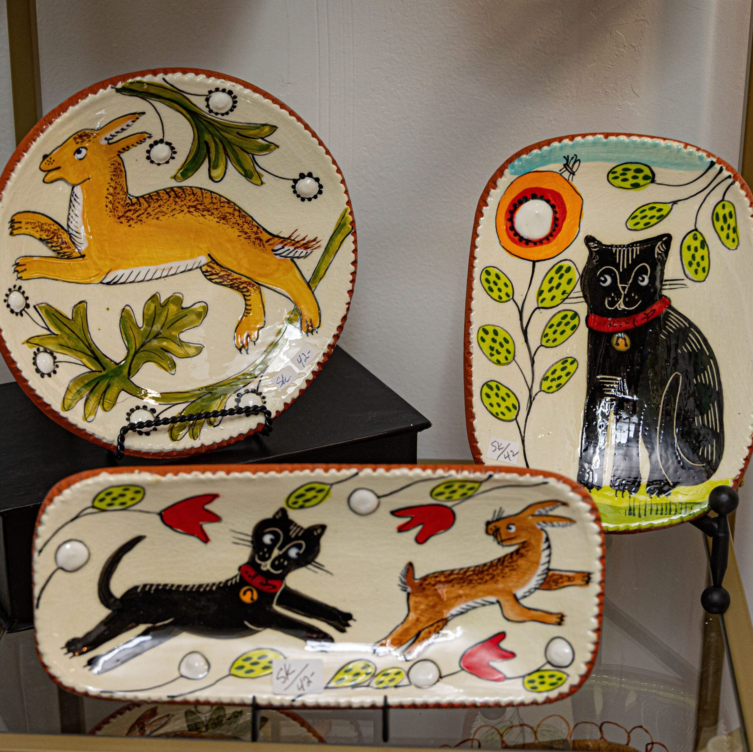 plates with designs of animals on the surface in a folk art style