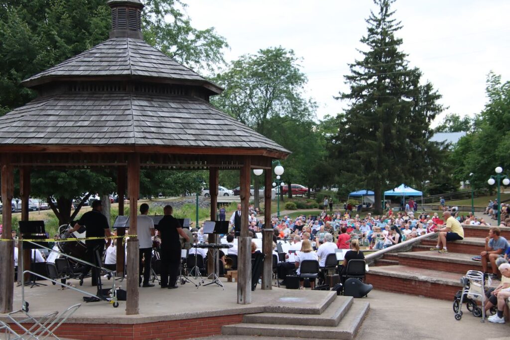 Downtown Lewisburg bandstand surrounded by crowd listening to music in the park