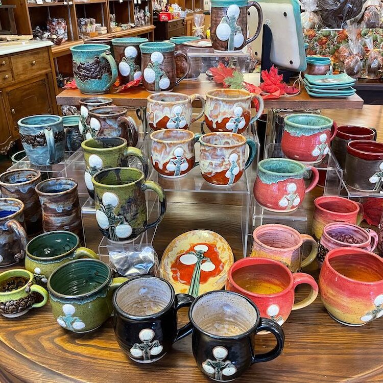 Erin Yust Brown Pottery picture of table filled with Lewisburg Lamp Post Mugs